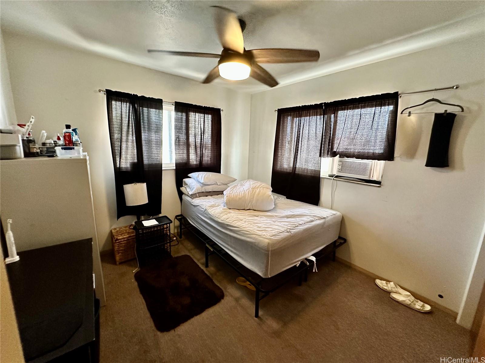 2205 Fern Street Honolulu, HI 96826 - Photo 11 of 13 a bedroom with a bed a table and flat screen tv