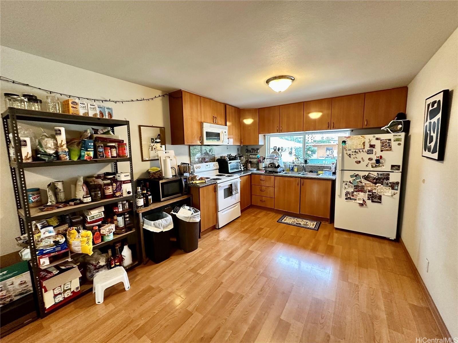 2205 Fern Street Honolulu, HI 96826 - Photo 3 of 13 a kitchen with stainless steel appliances wooden floor and large window