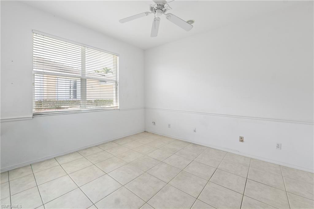 7737 Haverhill Court Naples, FL 34104 - Photo 18 of 37 Room featuring light-toned square tile flooring, a window with horizontal blinds, and a white ceiling fan