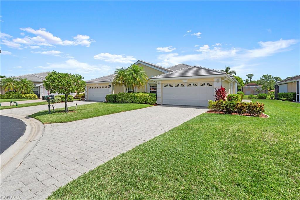 7737 Haverhill Court Naples, FL 34104 - Photo 2 of 37 Exterior featuring a concrete tile roof, two-car garage, paver driveway, and mature landscaping