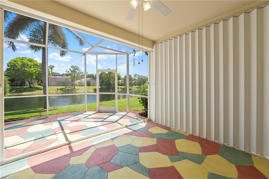 7737 Haverhill Court Naples, FL 34104 - Photo 26 of 37 Screened lanai featuring a colorful geometric-patterned floor, ceiling fan, and accordion hurricane shutters