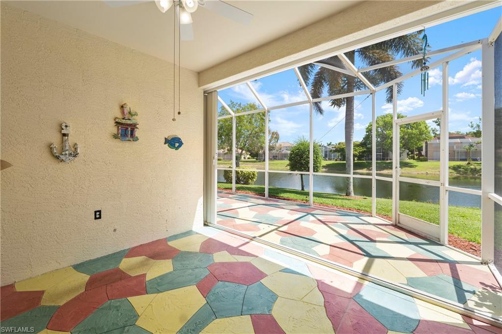 7737 Haverhill Court Naples, FL 34104 - Photo 27 of 37 Screened patio featuring a colorful geometric patterned floor, a ceiling fan with light fixture, and expansive water frontage