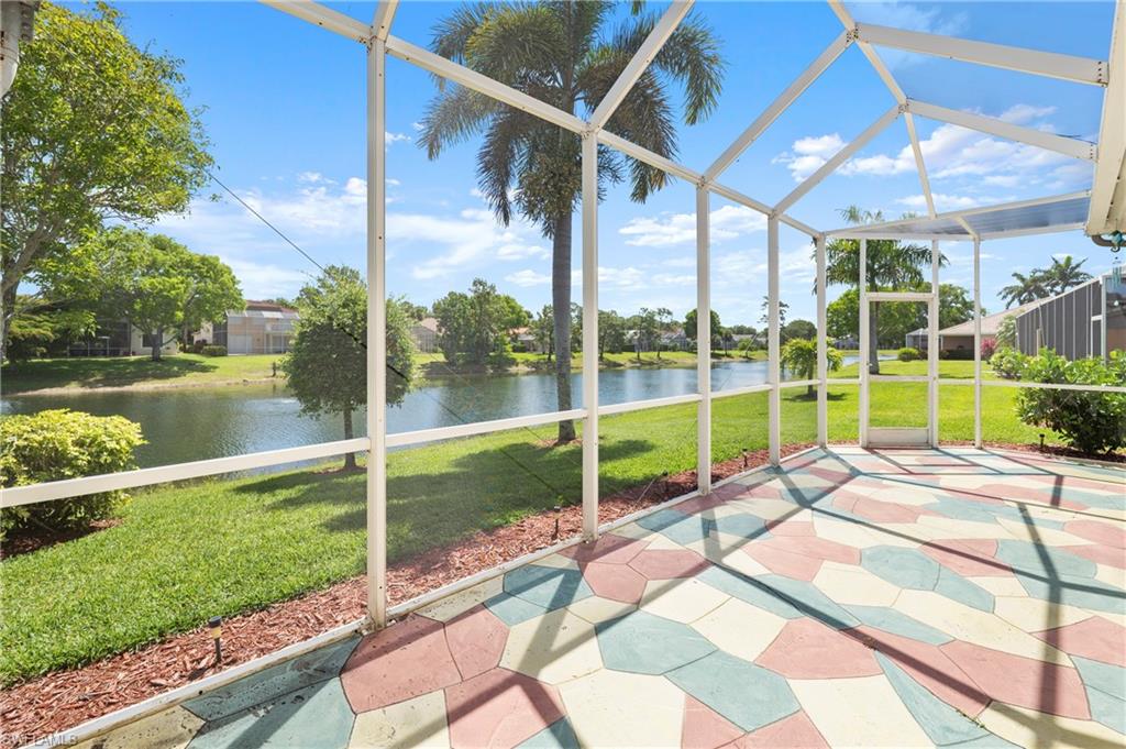 7737 Haverhill Court Naples, FL 34104 - Photo 29 of 37 Screened patio featuring a colorful geometric paver floor overlooking a water feature and established landscaping