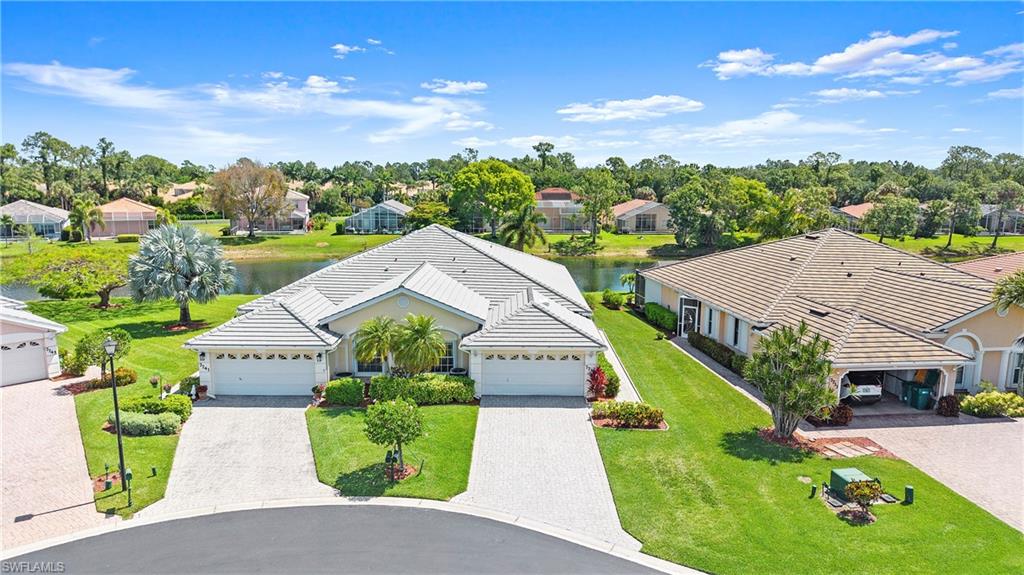 7737 Haverhill Court Naples, FL 34104 - Photo 31 of 37 Lakeside property featuring a tile roof, paver driveway, and an attached two-car garage
