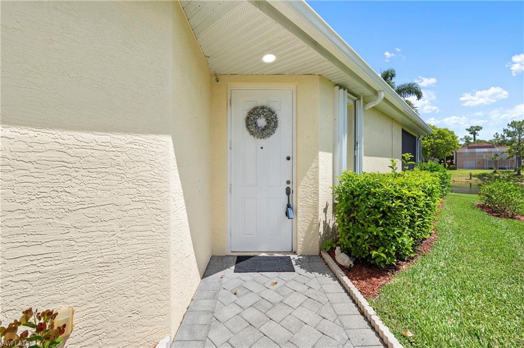 7737 Haverhill Court Naples, FL 34104 - Photo 4 of 37 Entryway featuring a paver walkway, stucco exterior, recessed lighting, and manicured landscaping