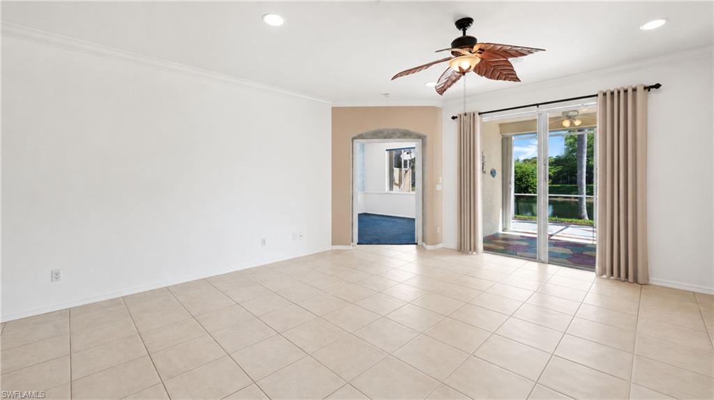 7737 Haverhill Court Naples, FL 34104 - Photo 5 of 37 Spacious room featuring tile flooring, crown molding, an arched doorway, and a ceiling fan