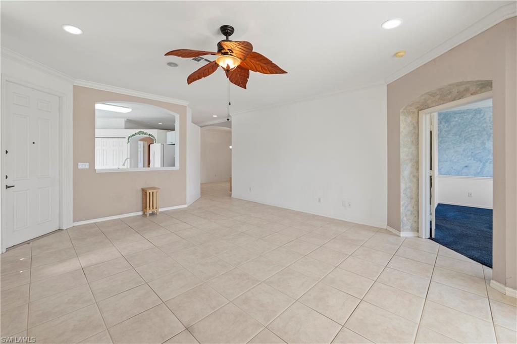 7737 Haverhill Court Naples, FL 34104 - Photo 7 of 37 Spacious interior featuring neutral ceramic tile flooring, a decorative ceiling fan, recessed lighting, crown molding, and an arched entryway
