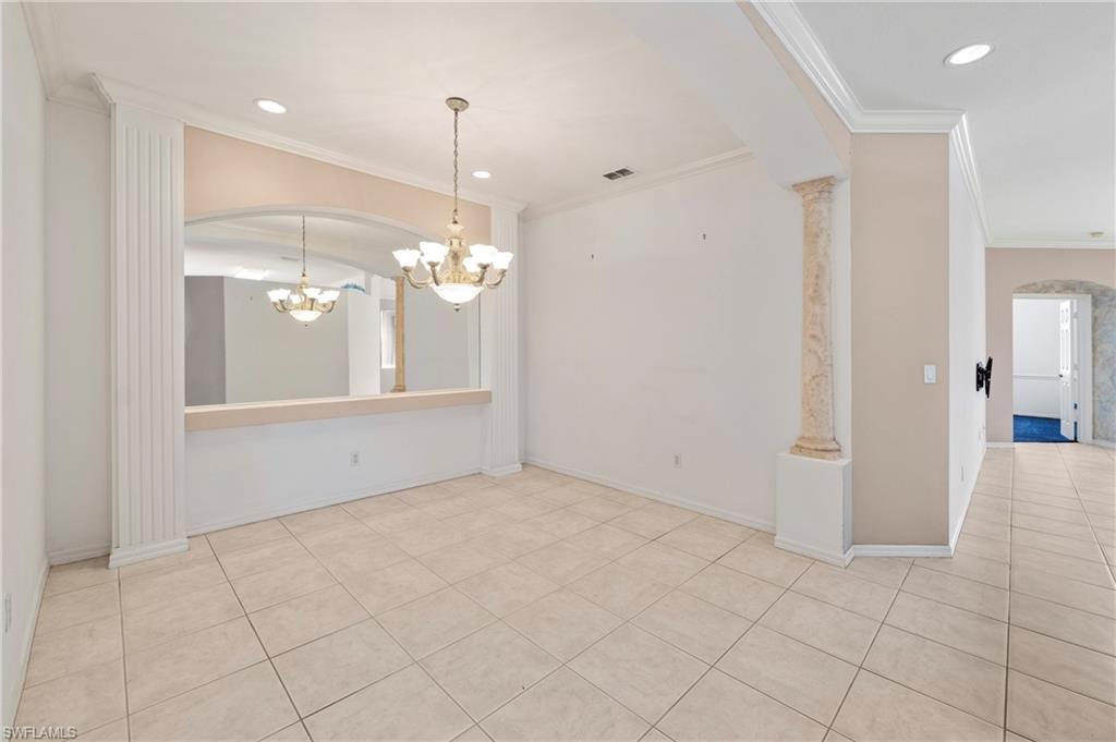 7737 Haverhill Court Naples, FL 34104 - Photo 9 of 37 Tiled flooring throughout, featuring decorative columns, recessed lighting, and a chandelier fixture