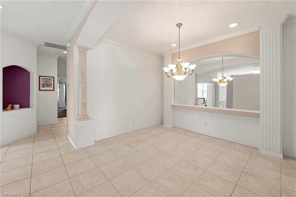 7737 Haverhill Court Naples, FL 34104 - Photo 10 of 37 Open living area featuring neutral tile flooring, decorative architectural columns, and a built-in arched niche