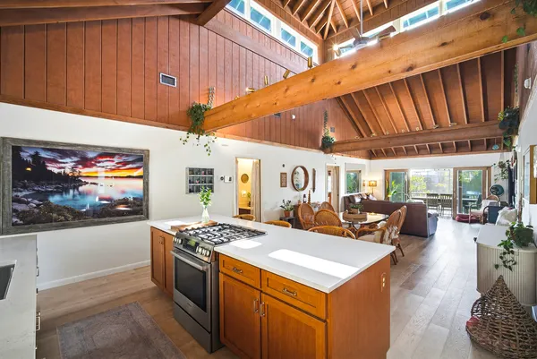 a view of a dining room with furniture one side kitchen view and wooden floor