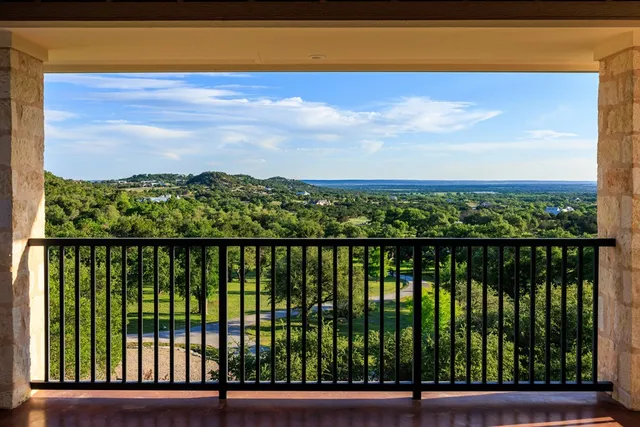 an aerial view of residential houses with outdoor space and trees all around