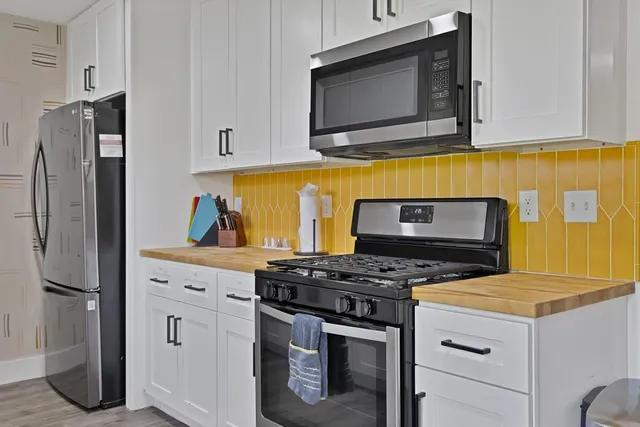 a kitchen with stainless steel appliances granite countertop a stove microwave and refrigerator