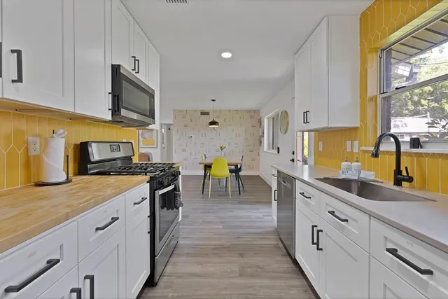 a kitchen with stainless steel appliances granite countertop sink stove top oven and cabinets