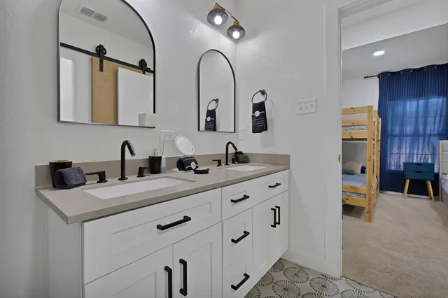 a bathroom with a double vanity sink and a mirror