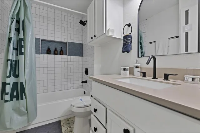 a bathroom with a toilet a sink a tub and mirror