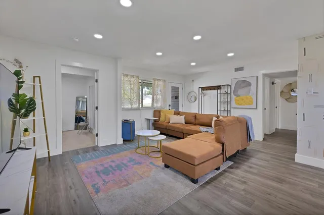 a living room with furniture and a wooden floor
