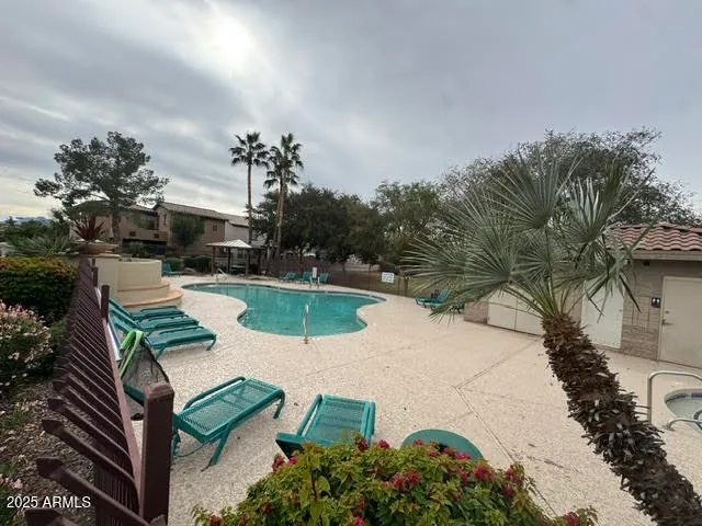 a view of a swimming pool with a table and chairs under an umbrella