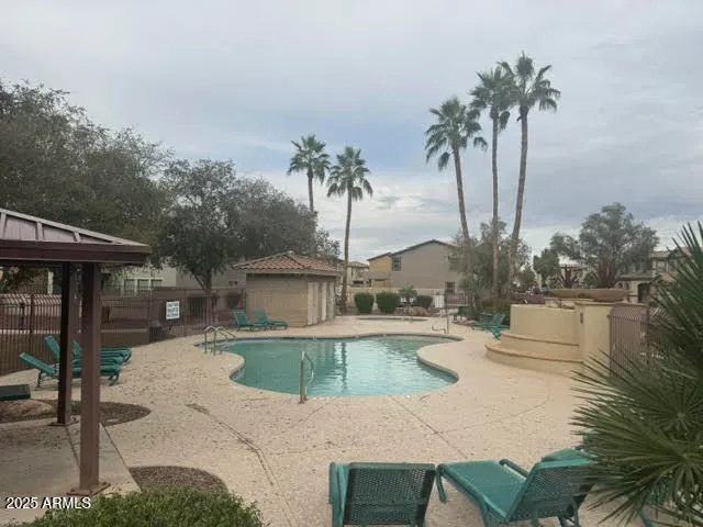 a view of a swimming pool with a patio and a yard