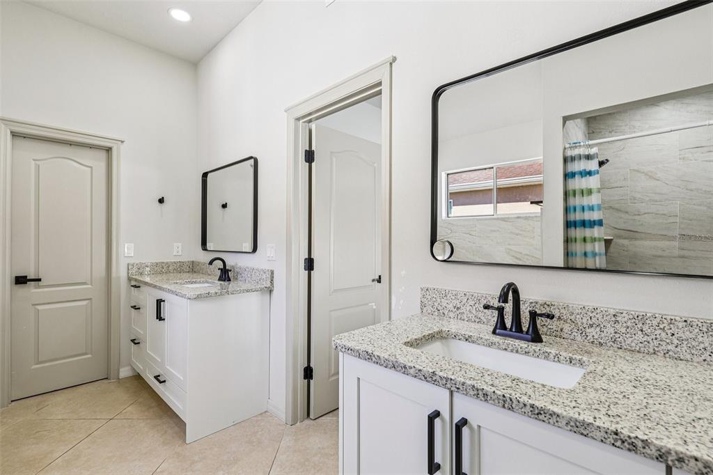 5 Watkins Place Palm Coast, FL 32164 - Photo 11 of 25 a bathroom with a granite countertop sink double vanity and a mirror