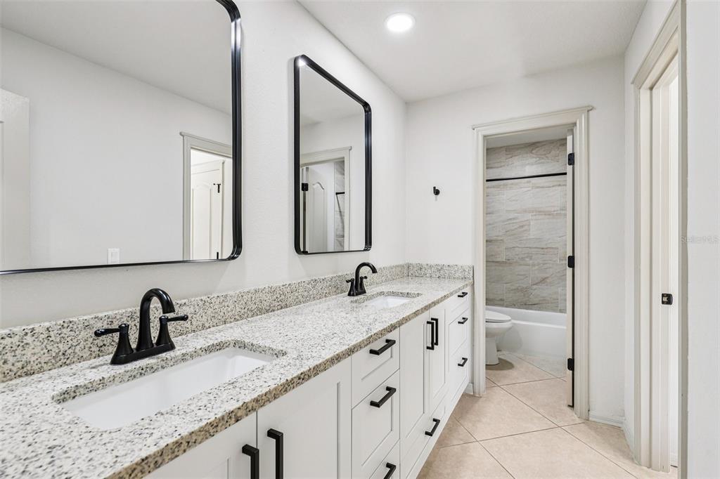 5 Watkins Place Palm Coast, FL 32164 - Photo 14 of 25 a bathroom with a granite countertop sink and a mirror