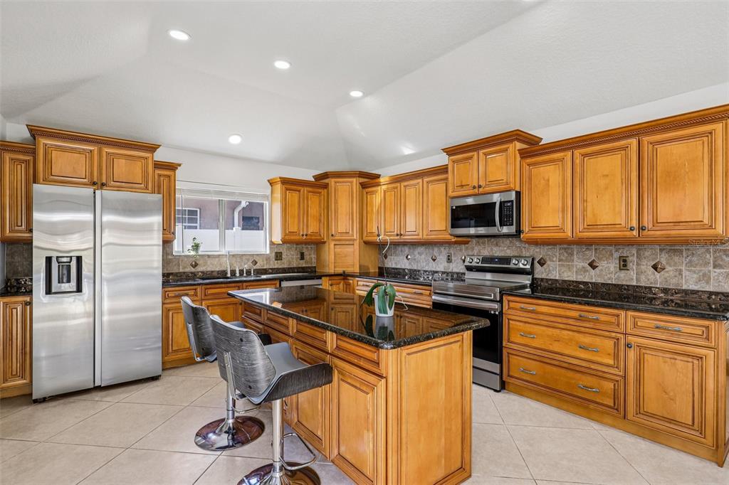 5 Watkins Place Palm Coast, FL 32164 - Photo 7 of 25 a kitchen with stainless steel appliances granite countertop a stove a sink a microwave and a refrigerator