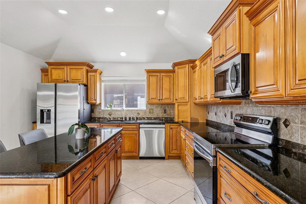 5 Watkins Place Palm Coast, FL 32164 - Photo 8 of 25 a kitchen with stainless steel appliances granite countertop a stove a sink and a microwave