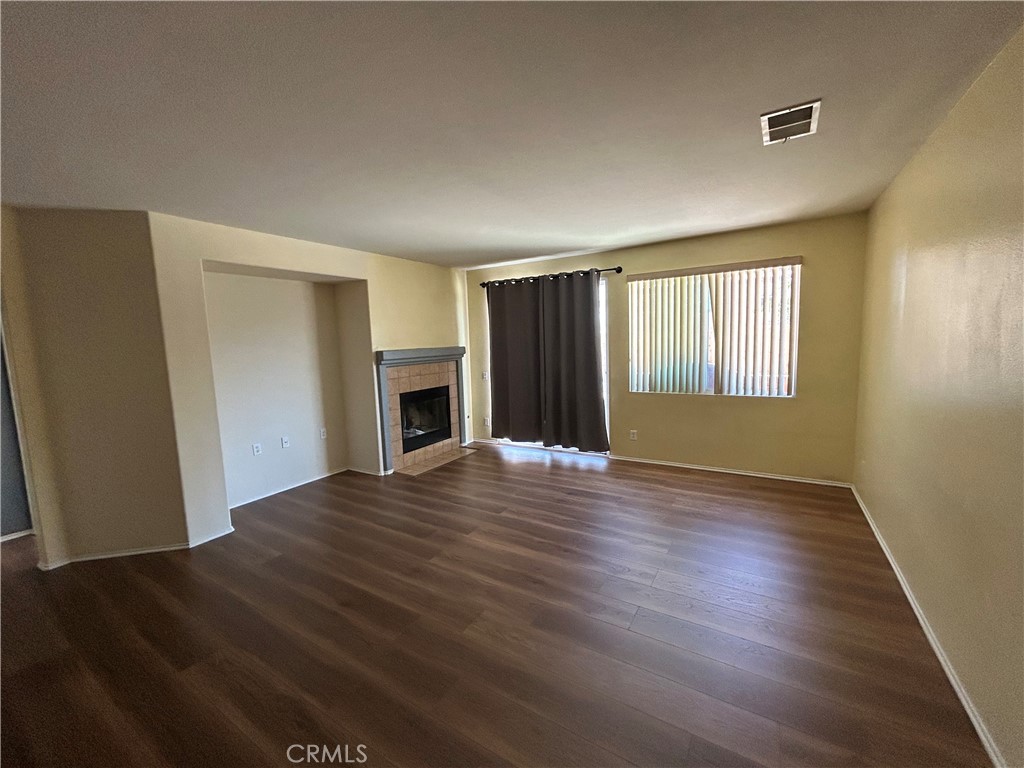 12673 Field Way Victorville, CA 92395 - Photo 3 of 15 a view of an empty room with window and wooden floor