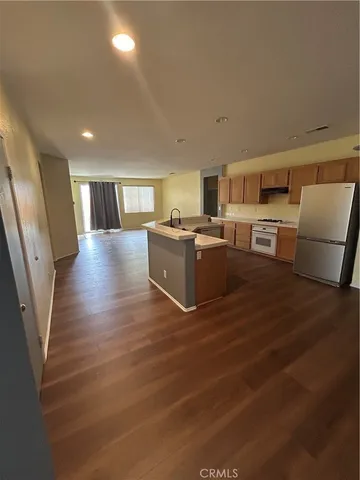 a view of a kitchen with furniture and wooden floor