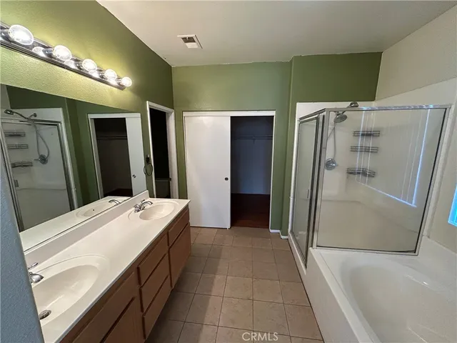 a bathroom with a double vanity sink toilet and shower