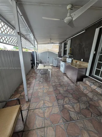 a outdoor space with lots of white furniture and a rug
