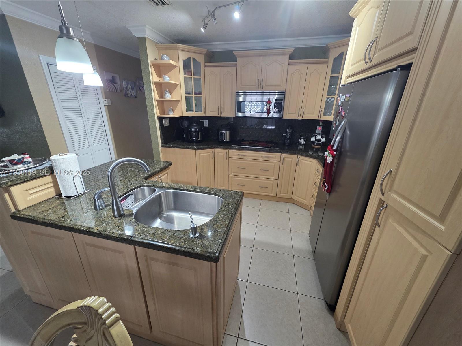 3600 East 5th Avenue Hialeah, FL 33013 - Photo 9 of 13 a kitchen with granite countertop a sink and a refrigerator