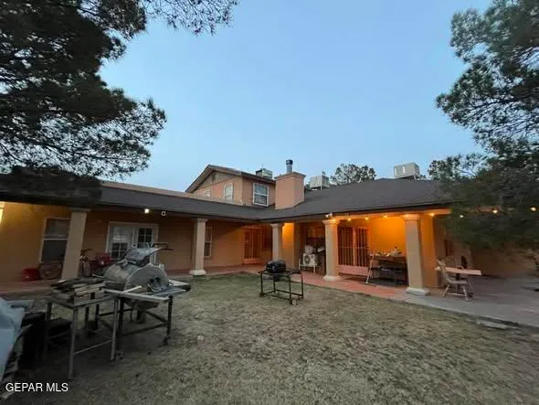 a view of a patio with table and chairs and a large tree