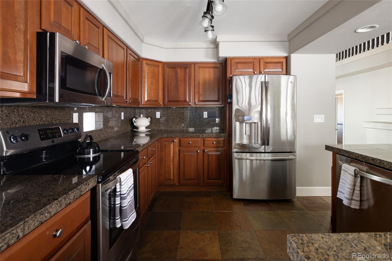 10269 Fawnbrook Court Highlands Ranch, CO 80130 - Photo 12 of 45 a kitchen with stainless steel appliances granite countertop a refrigerator a stove top oven a sink and dishwasher