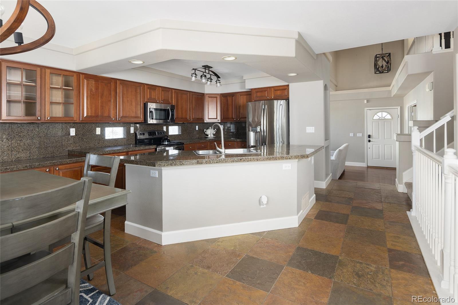 10269 Fawnbrook Court Highlands Ranch, CO 80130 - Photo 15 of 45 a kitchen with stainless steel appliances kitchen island granite countertop a sink and cabinets