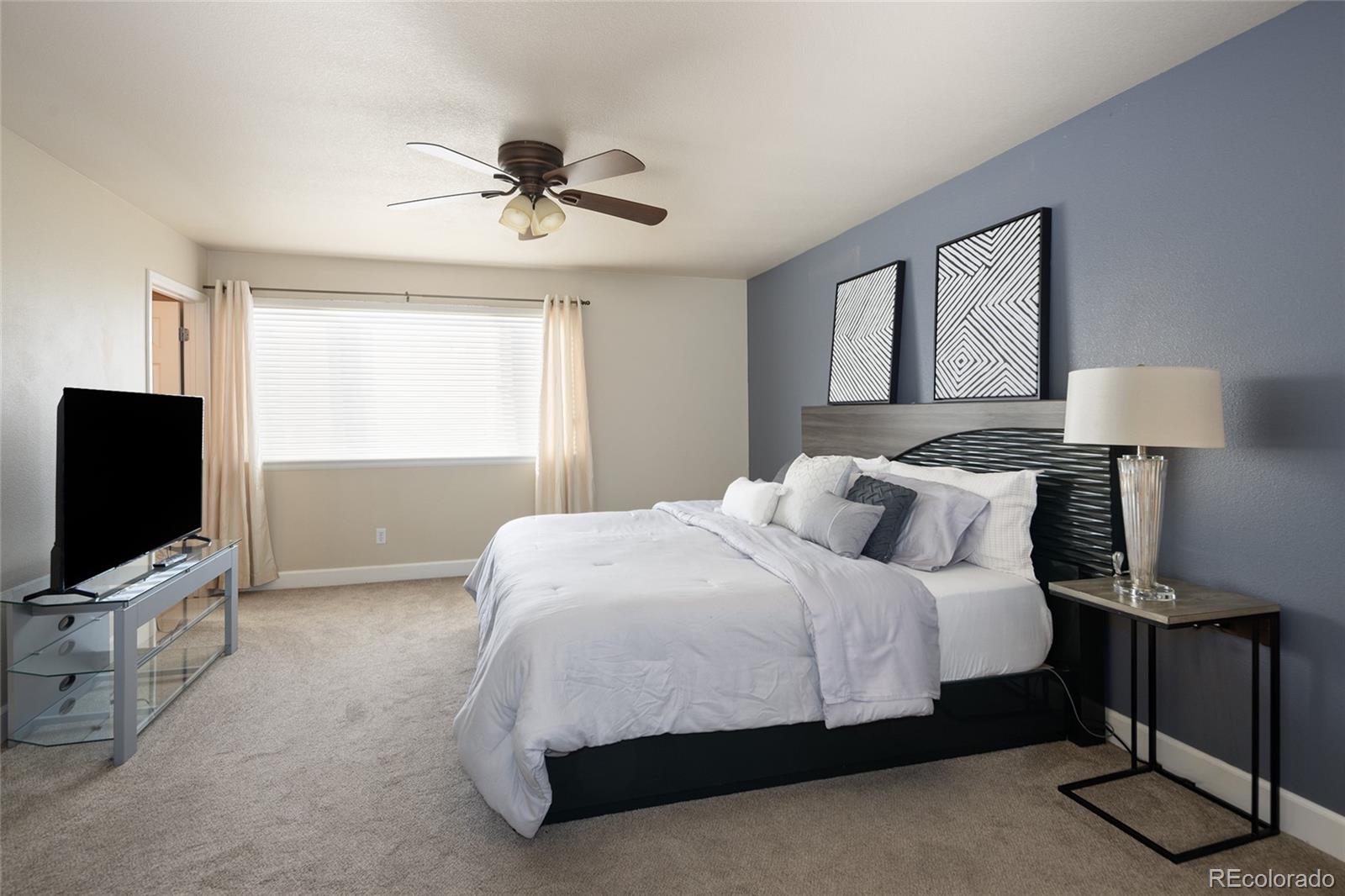 10269 Fawnbrook Court Highlands Ranch, CO 80130 - Photo 20 of 45 a bedroom with a bed flat screen tv and a window