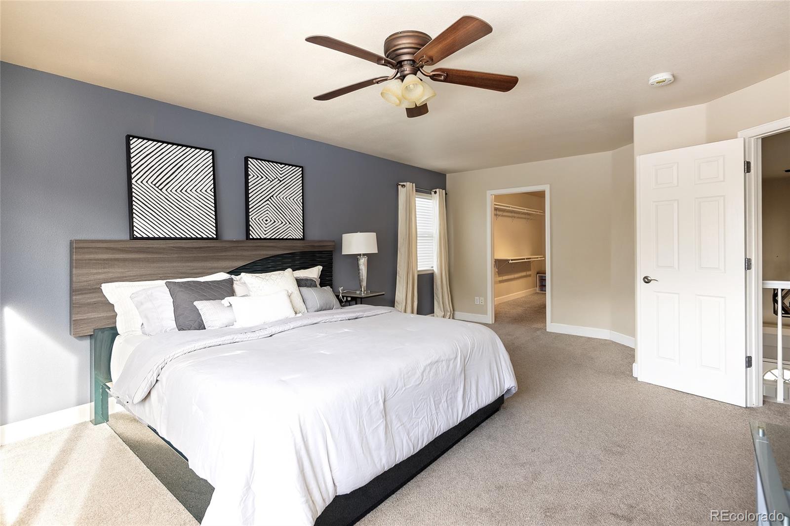 10269 Fawnbrook Court Highlands Ranch, CO 80130 - Photo 21 of 45 a bedroom with a large bed and ceiling fan