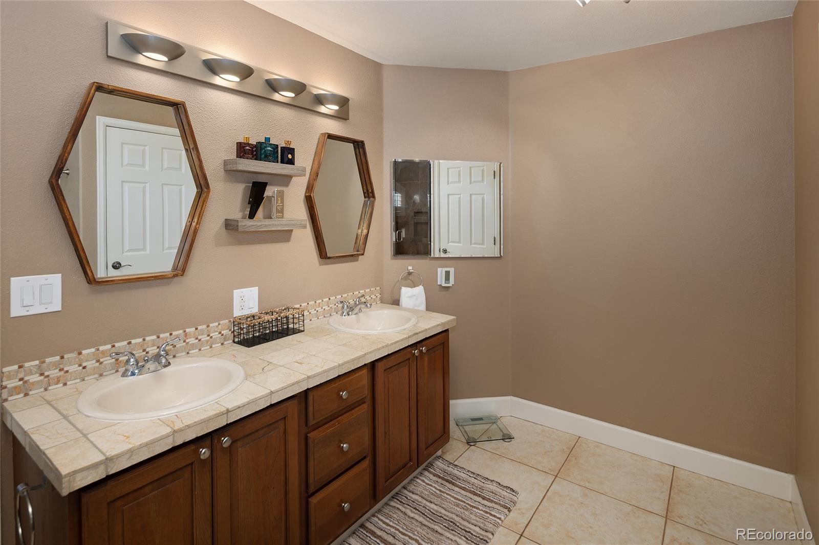 10269 Fawnbrook Court Highlands Ranch, CO 80130 - Photo 23 of 45 a bathroom with a sink vanity and a mirror
