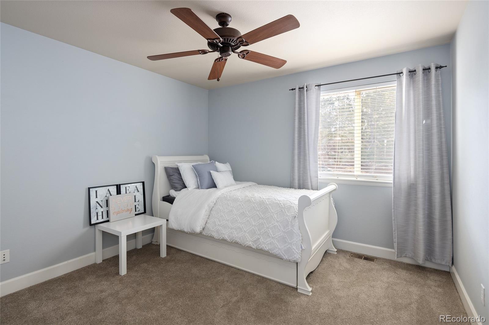 10269 Fawnbrook Court Highlands Ranch, CO 80130 - Photo 25 of 45 a bedroom with a bed a chandelier and a window