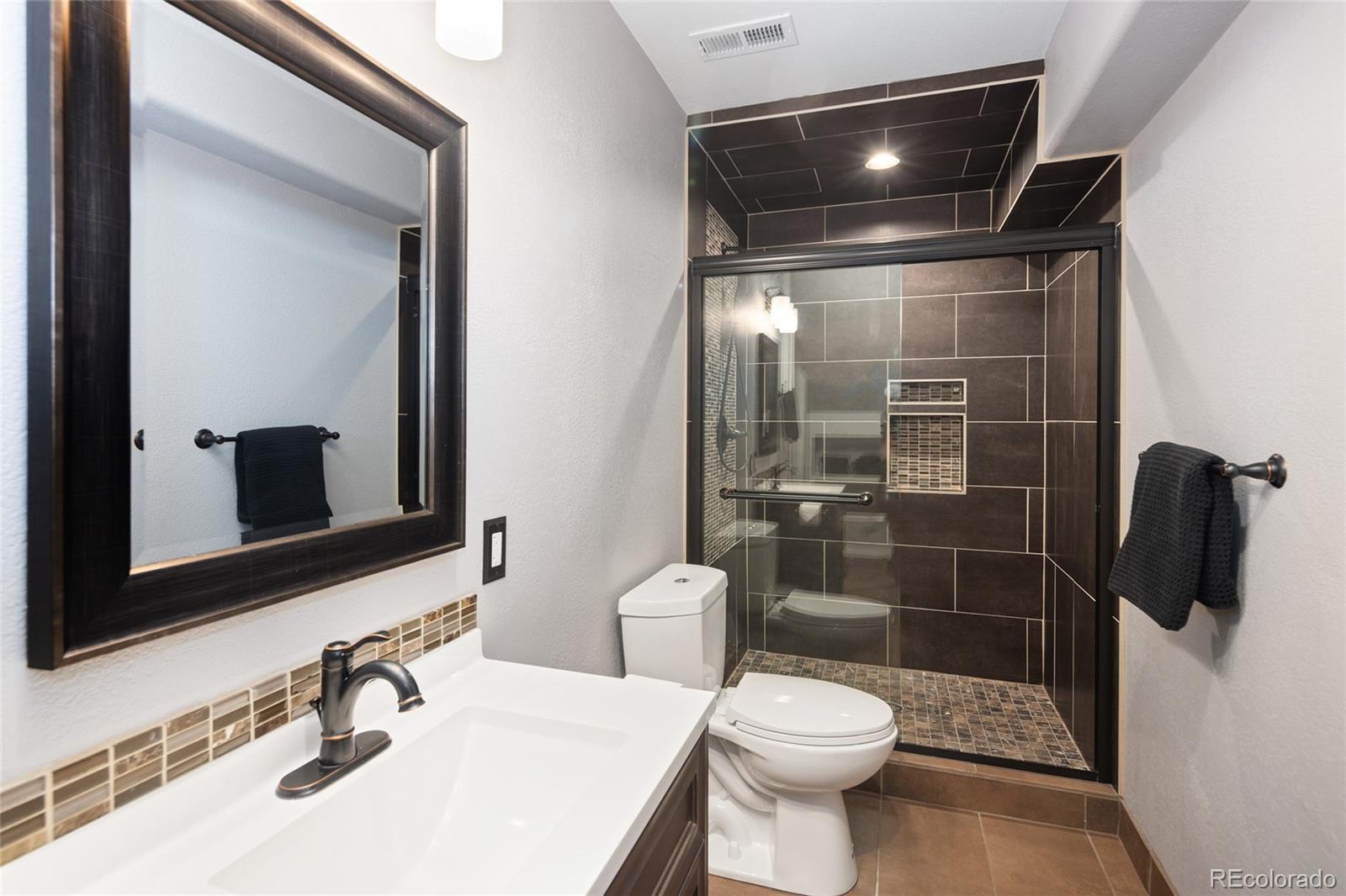 10269 Fawnbrook Court Highlands Ranch, CO 80130 - Photo 32 of 45 a bathroom with a toilet a sink and shower
