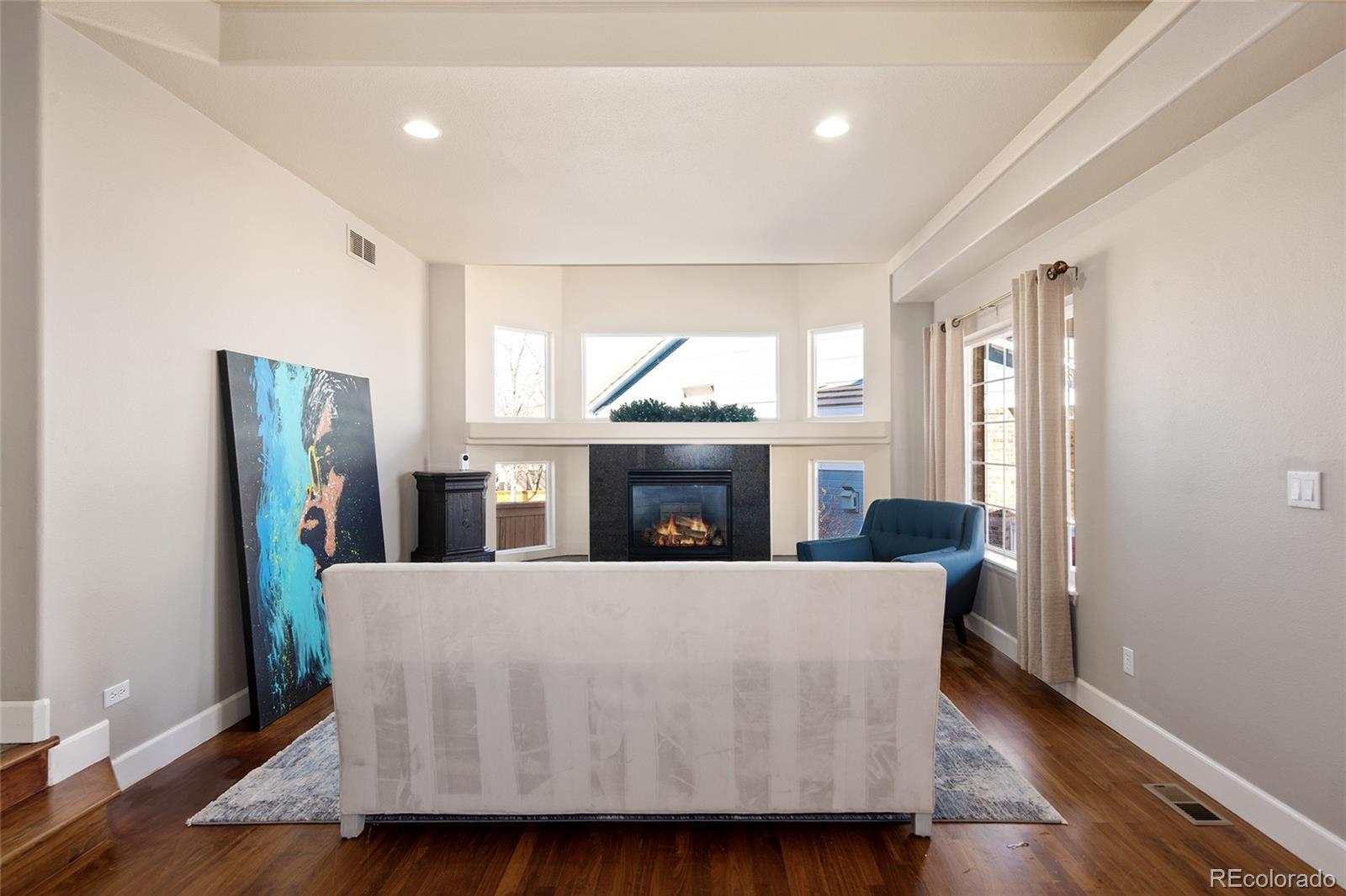 10269 Fawnbrook Court Highlands Ranch, CO 80130 - Photo 10 of 45 a living room with furniture wooden floor and a fireplace