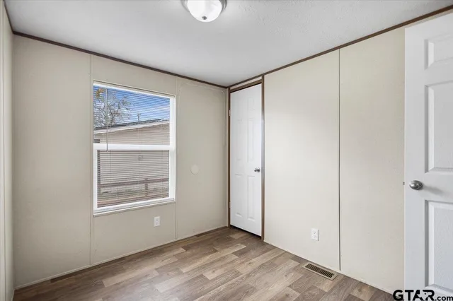 a view of an empty room with closet and a window