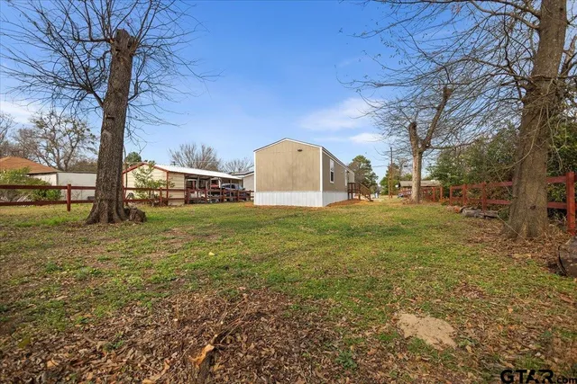 a view of a field with large trees