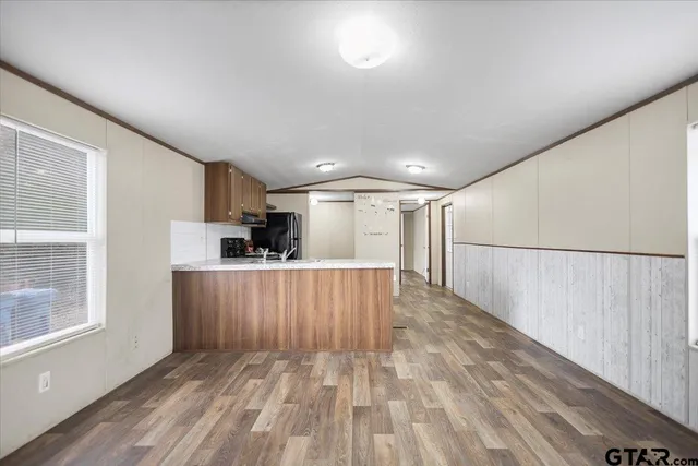 a view of a kitchen with wooden floor and a window