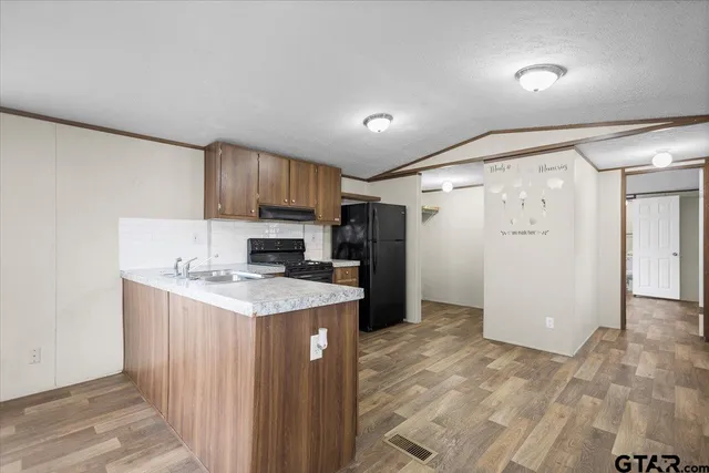 a kitchen with a stove a refrigerator and a sink