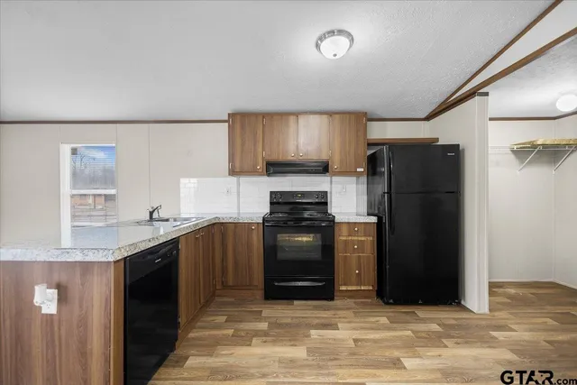 a kitchen with granite countertop a refrigerator stove and sink