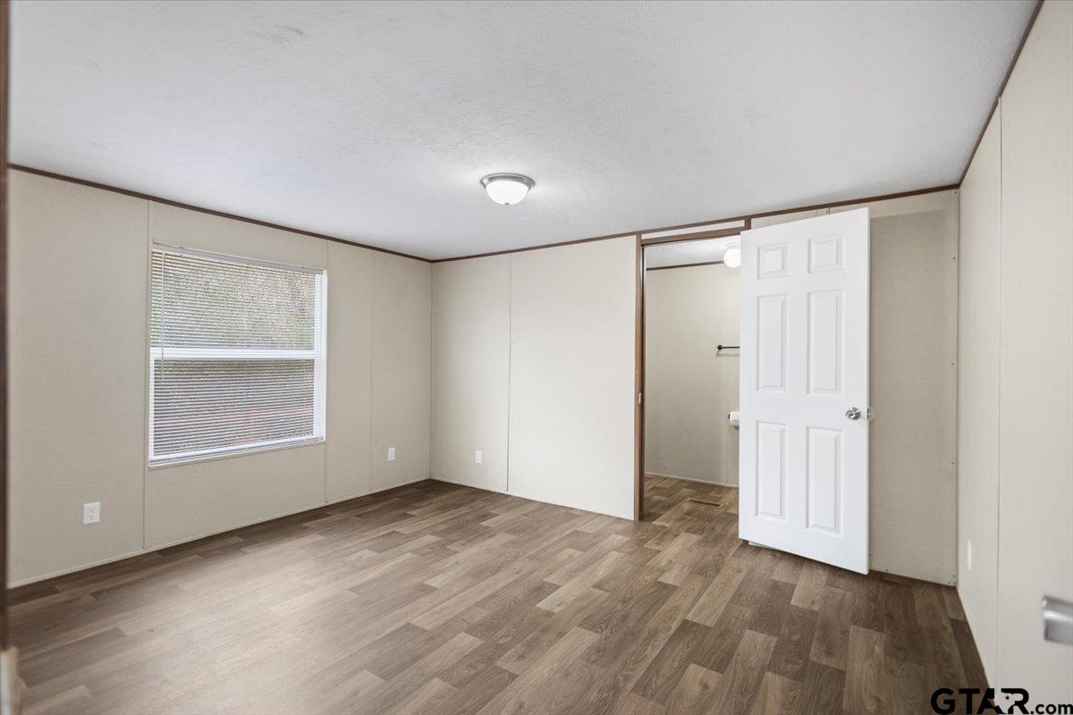 307 St Joseph Street Athens, TX 75751 - Photo 8 of 24 an empty room with wooden floor and windows