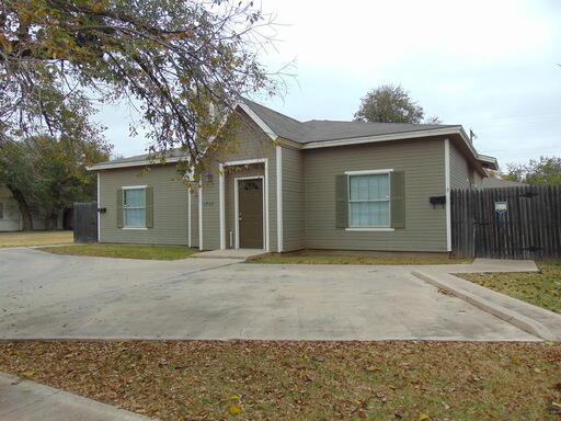 1712 23rd Street, Unit B Lubbock, TX 79411 - Photo 1 of 9 a front view of a house with a yard and garage