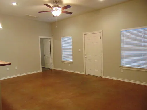 an empty room with closet and a chandelier fan