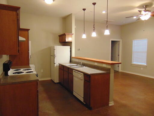 1712 23rd Street, Unit B Lubbock, TX 79411 - Photo 5 of 9 a kitchen with a stove and a wooden floor