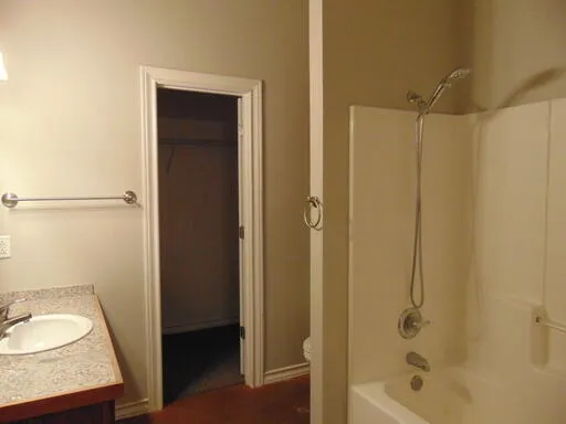 a bathroom with a granite countertop sink a toilet and shower
